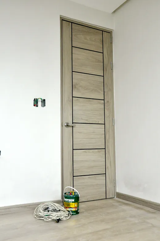 Full-height pale oak Polydoor in a tiled room